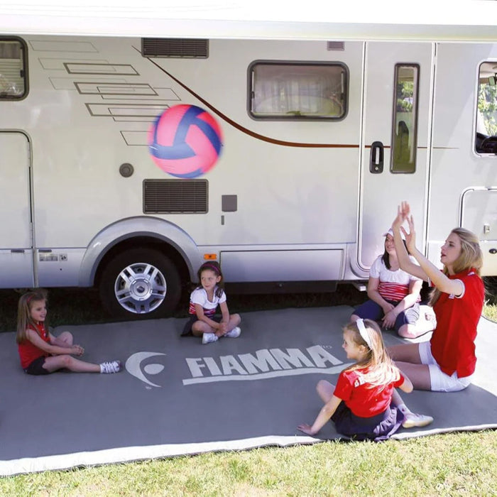 Fiamma Patio-Mat 390 instalada bajo el toldo de una autocaravana, ideal como alfombra exterior para camping.