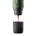 Extracción de espresso con la cafetera portátil OutIn Nano verde bosque vertiendo café en vaso negro