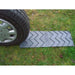 Placa de tracción antideslizante Milenco colocada bajo la rueda del coche sobre terreno blando