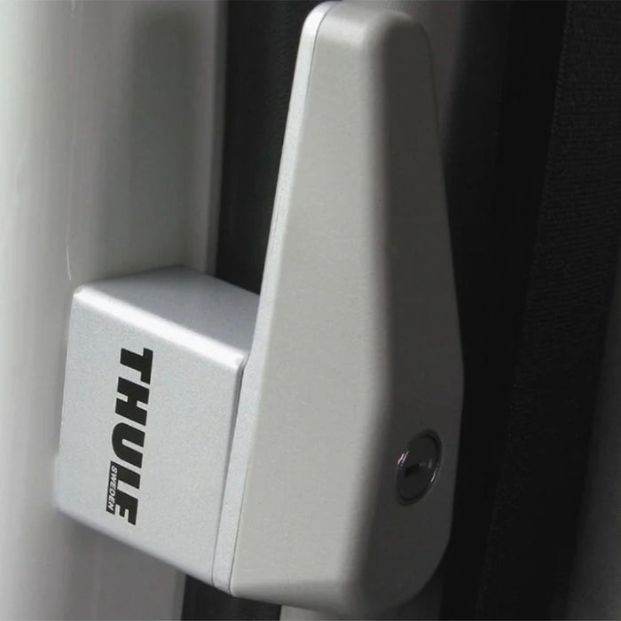 Cerradura Thule Cab Lock en posición vertical colocada en el marco de la puerta.