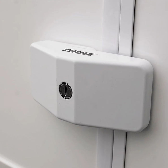 Bloqueador de puerta Thule Door Lock blanco instalado en la puerta para mayor seguridad.